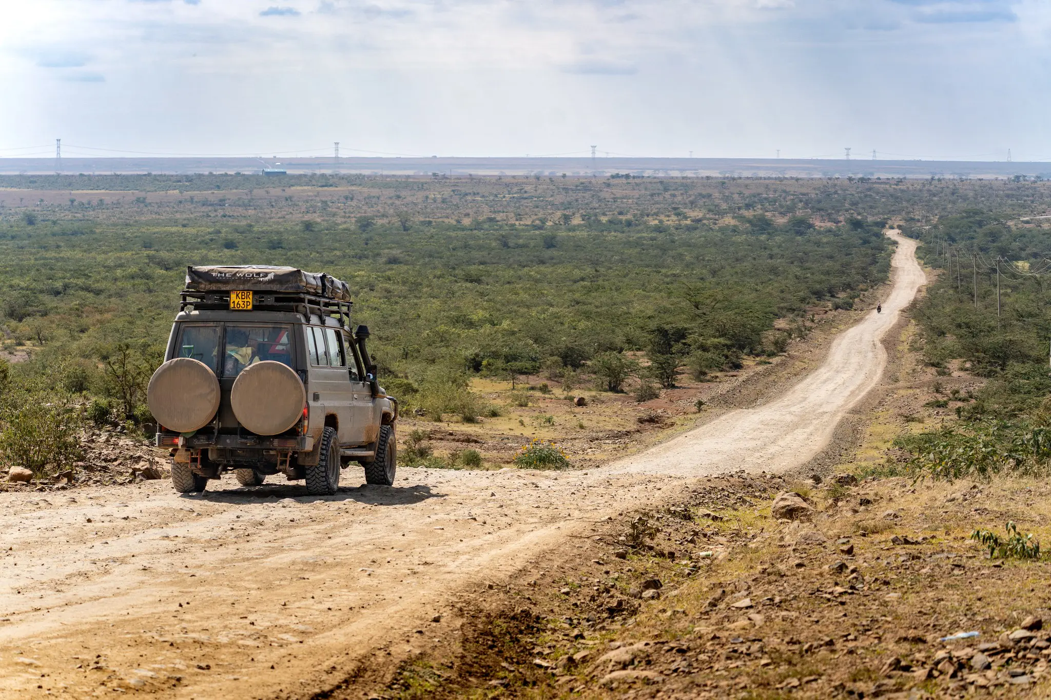 safari vehicle on a dirt road in the Kenyan savanna