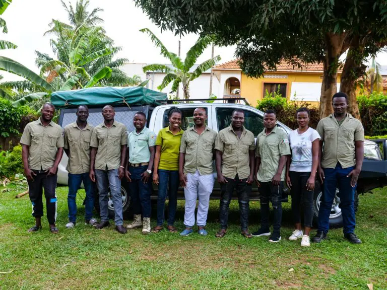 group of Roadtrip Africa staff posing with a safari vehicle in Uganda