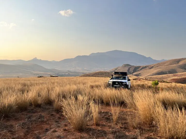 white 4x4 with rooftop tent in golden grassy hills of Madagascar
